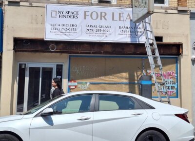 A storefront with a "FOR LEASE" sign from NY Space Finders, displaying contact information for Luca Diciero, Faisal Gilani, and Damian Pak. A white car is parked in front, and a man walks by. A ladder leans against the building, and the windows are covered.
